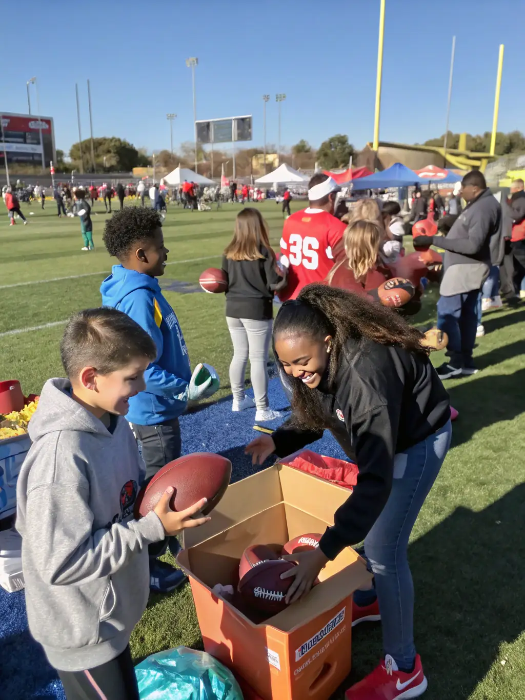 A photograph of a community outreach event where football equipment is being donated to underprivileged children, emphasizing the Football for All initiative.